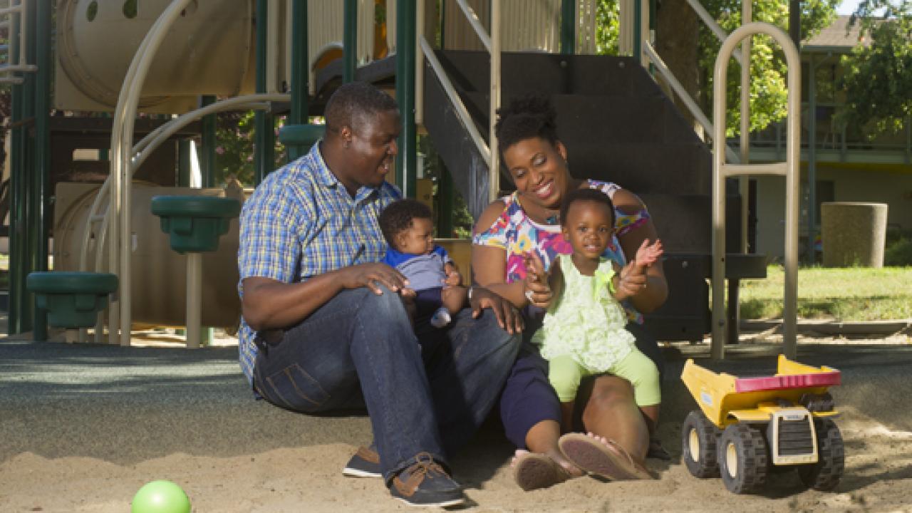 African American family sitting at playground