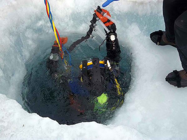 Tyler bringing samples up through an ice hole