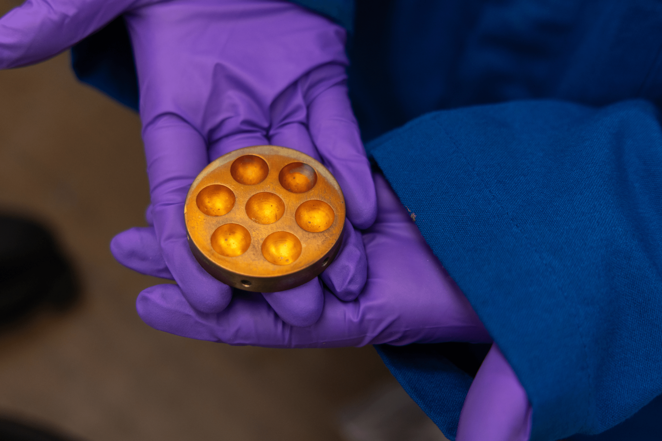 O'Shea holds a copper hearth, which is used to form materials samples into balls. (Mario Rodriguez/UC Davis)