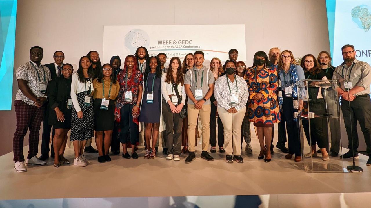 Vice Chancellor Renetta Tull stands with members of PROMISE Engineering Institute Mentoring Academy on stage at a conference in Cape Town, South Africa.