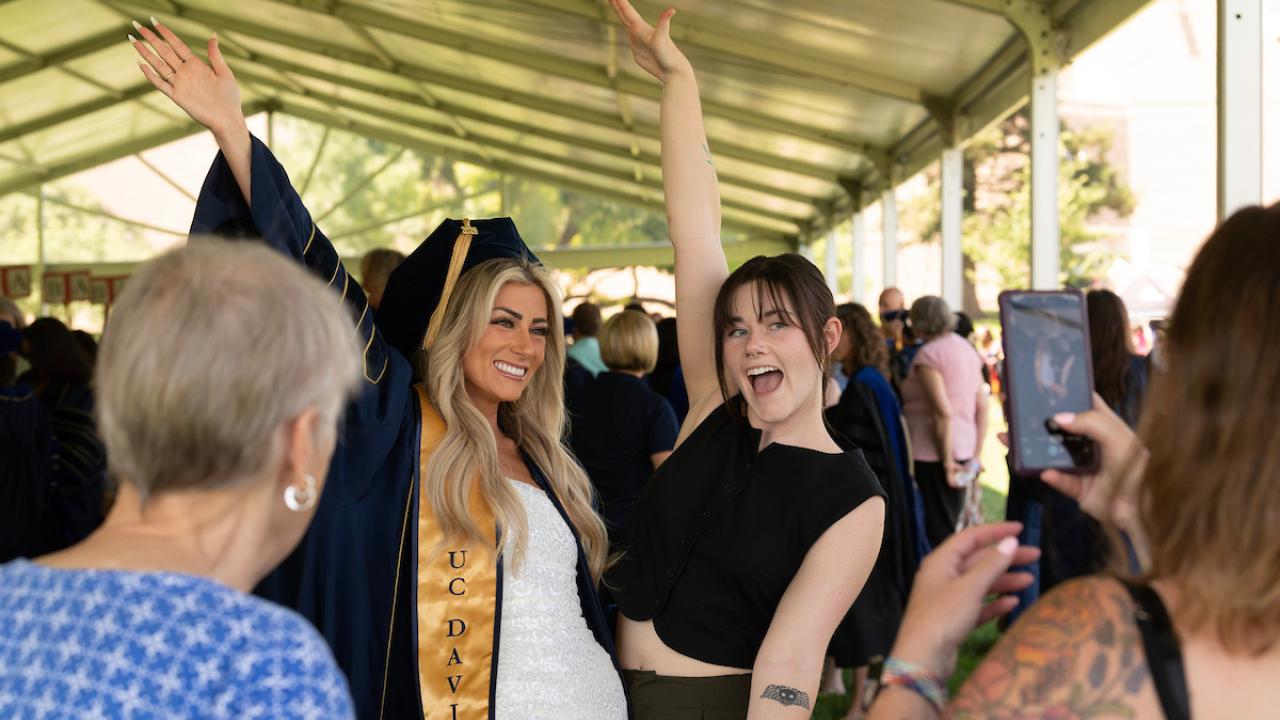 Parent taking photo of graduate.