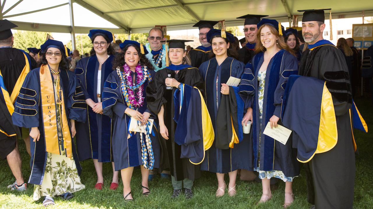 Group of MFA and Doctoral graduates smiling.