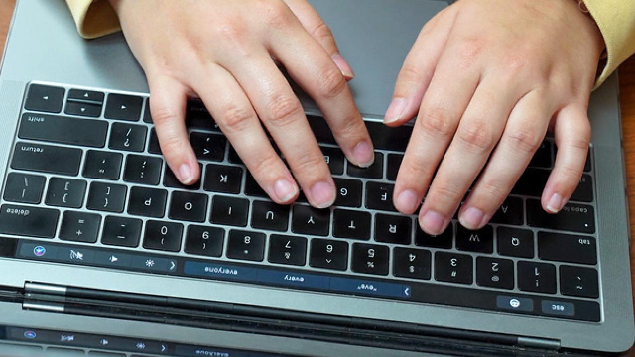 Hands typing on a keyboard.