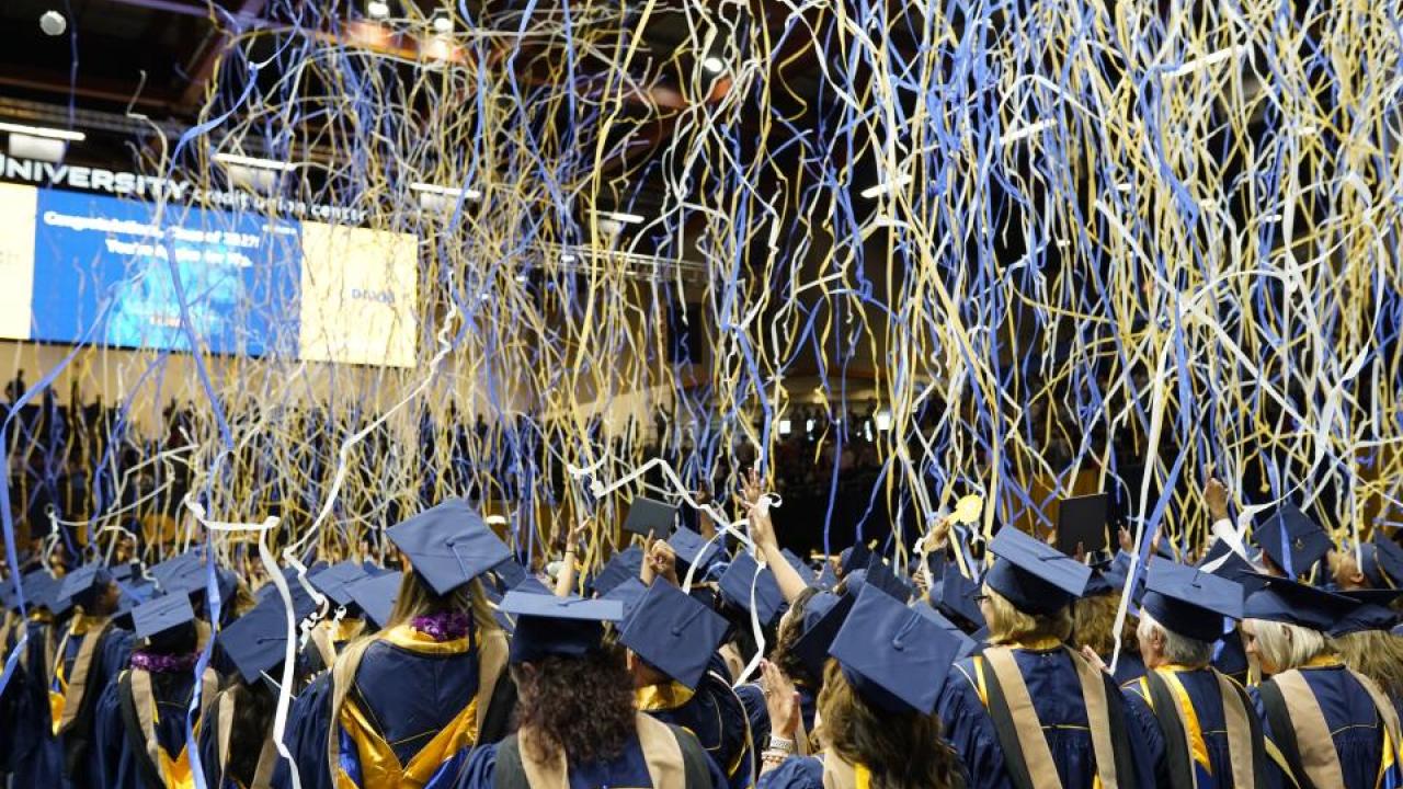 Streamers fall as graduates cheer.