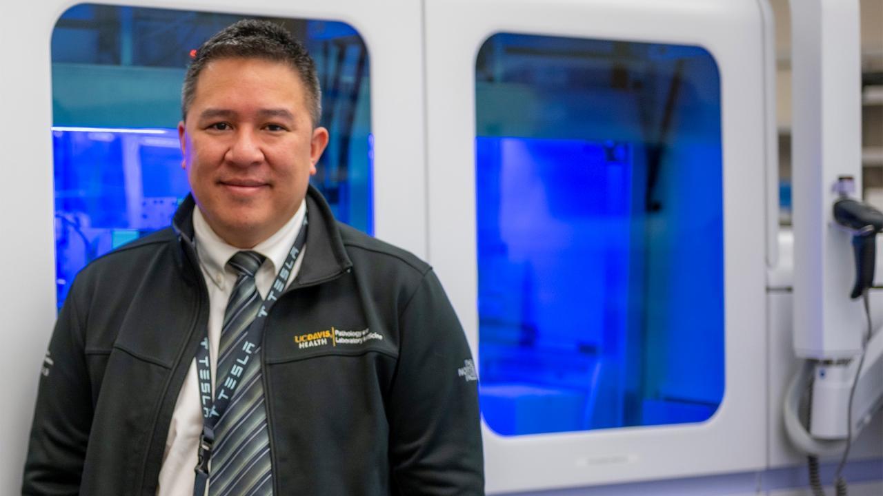 Professor Nam Tran stands in front of the Roche cobas 6800, which allowed UC Davis to quickly scale up COVID-19 testing in 2020.