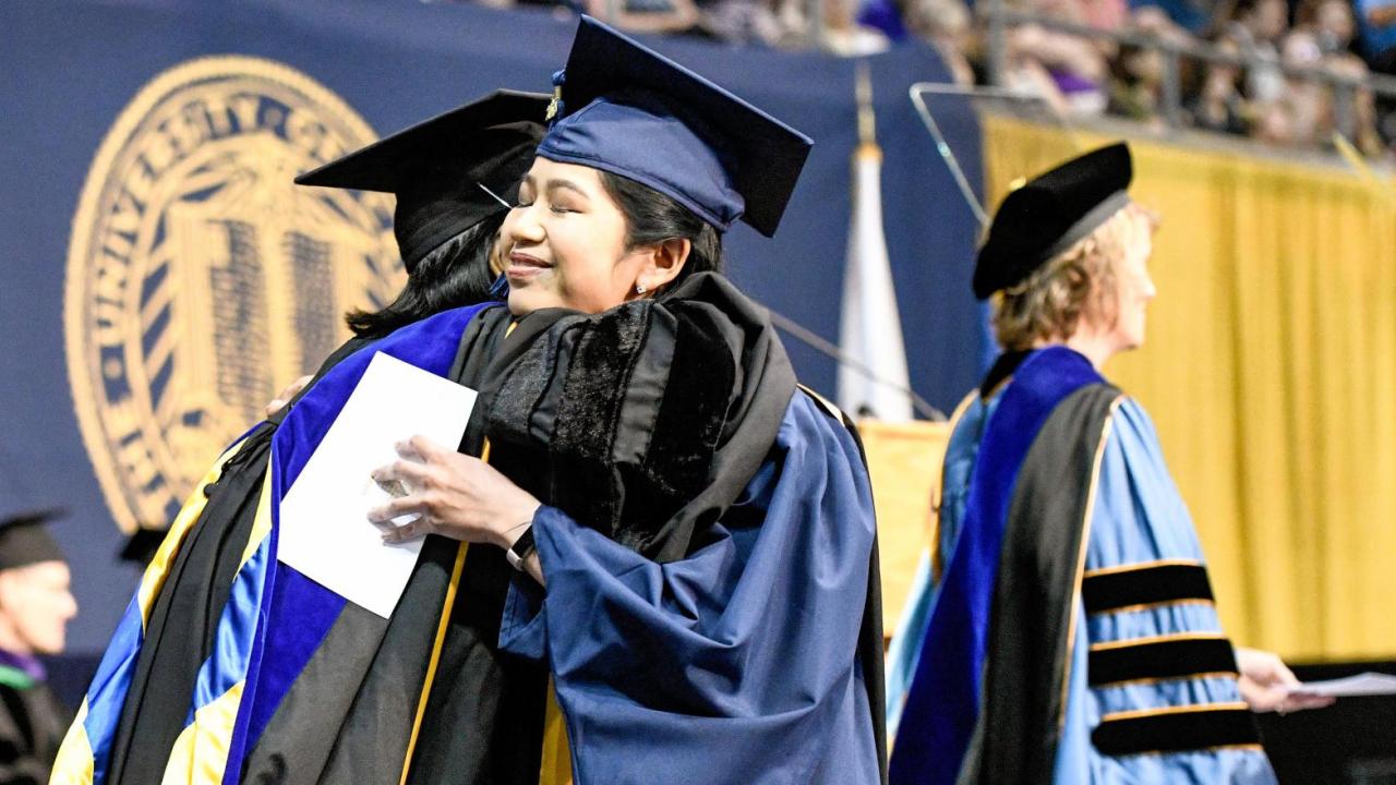 People hugging at the Graduate Studies Commencement
