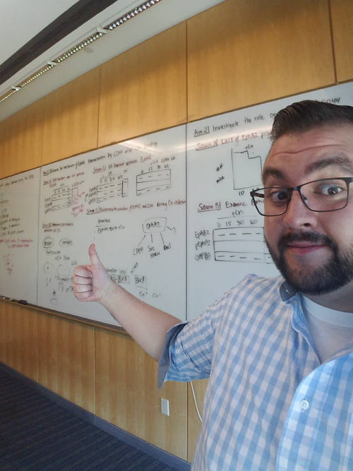 Javier Garcia stands in front of a white board with formulas written on it.
