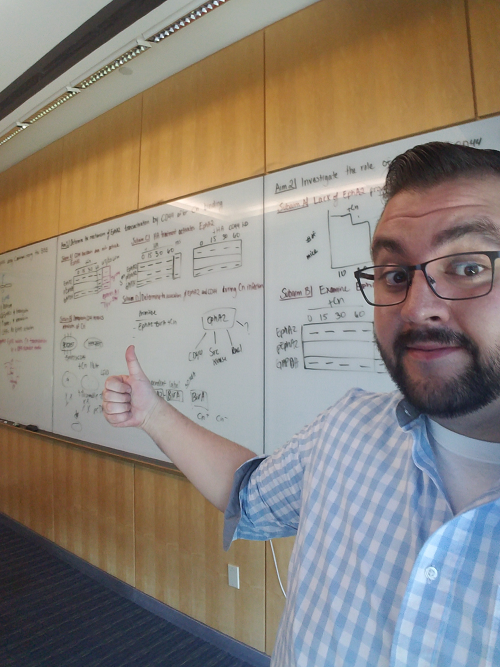 Javier Garcia stands in front of a white board with formulas written on it. 