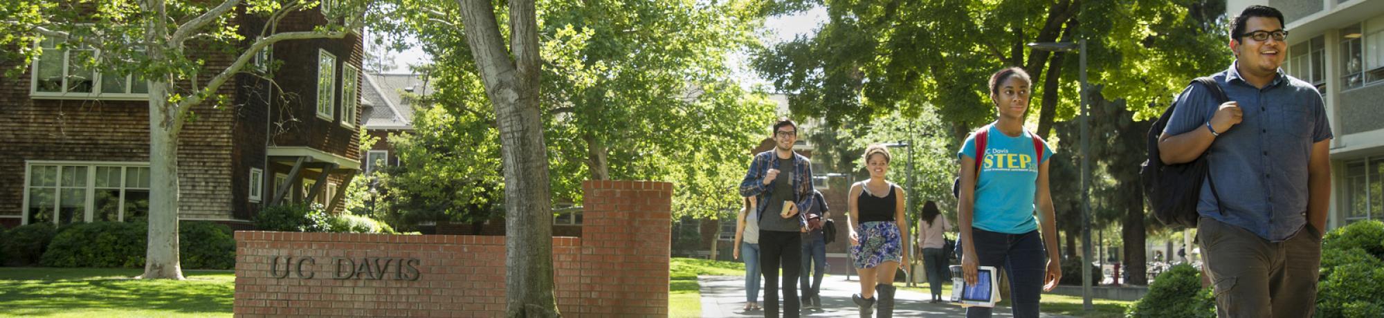 Students walking by a UC Davis sign.