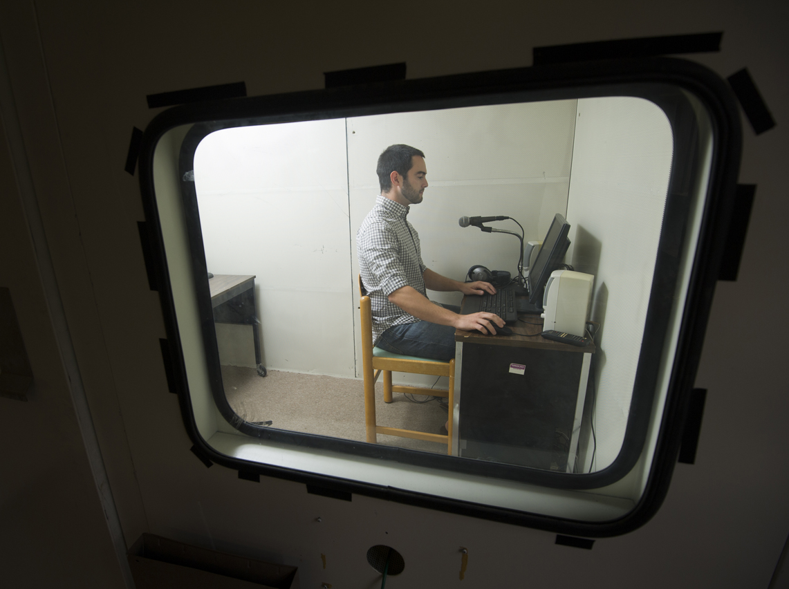 Villarreal sitting at a desk in a sound-attenuated booth 