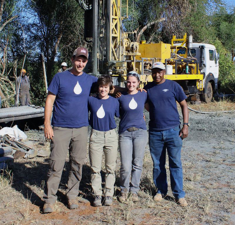 Markovich and 3 colleagues in front of drilling rig